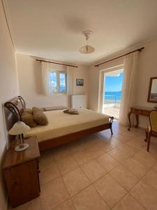 a bedroom with a large bed with a view of the ocean at Country house Nafpaktos in Nafpaktos