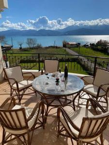 a patio with a table and chairs with a view of the water at Country house Nafpaktos in Nafpaktos