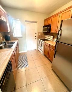 a kitchen with a stainless steel refrigerator and wooden cabinets at Beach Bungalow in downtown Cocoa Beach in Cocoa Beach