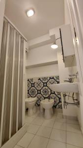 ein Badezimmer mit 2 WCs und einem Waschbecken in der Unterkunft Oltremare Marzamemi in Marzamemi
