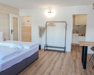 a bedroom with a bed and a table and a kitchen at Allgäuer Loft in Oberstaufen
