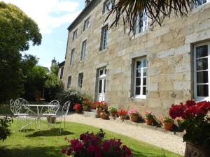 - un jardin avec une table et des chaises en face d'un bâtiment dans l'établissement Maison de Benedicte, à Saint-Brieuc