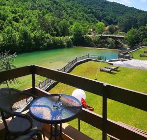 a balcony with a table and a view of a lake at Jazina Hotel in Trebinje