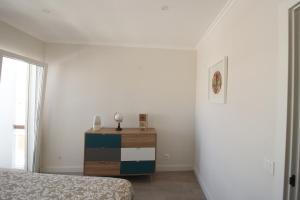 - une chambre avec un lit, une commode et une fenêtre dans l'établissement Downtown Dreams, à Faro