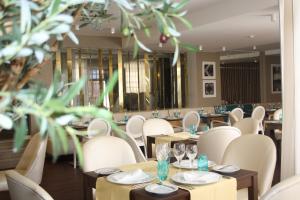 a restaurant with white chairs and tables with glasses at Josefa D`Obidos Hotel in Óbidos