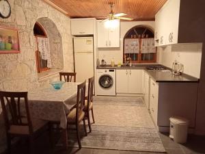 a kitchen with a table with chairs and a stove at Detached stone house with access to a large garden near beach in Kemer