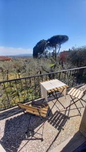una mesa de picnic y una silla en el balcón en OPERA21 TUSCANY SINGLE HOUSE LUCIGNANO, en Lucignano