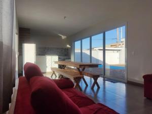 a living room with a red couch and a table at Casa Lazer com piscina in Brotas