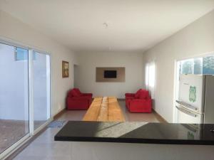 ein Wohnzimmer mit roten Stühlen und einem Kühlschrank in der Unterkunft Casa Lazer com piscina in Brotas