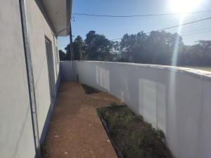eine weiße Wand neben einem Gebäude neben einem Zaun in der Unterkunft Casa Lazer com piscina in Brotas