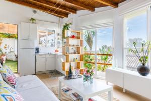 eine Küche und ein Wohnzimmer mit weißen Schränken und einem Tisch in der Unterkunft Villa la Orilla in Benajarafe