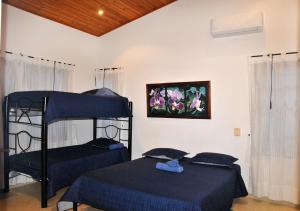 a bedroom with two beds and a picture of flowers at Incluye auxiliar doméstica PISCINA PRIVADA in Girardot