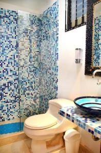 La salle de bains est pourvue de toilettes et d'une douche en verre. dans l'établissement Incluye auxiliar doméstica PISCINA PRIVADA, à Girardot