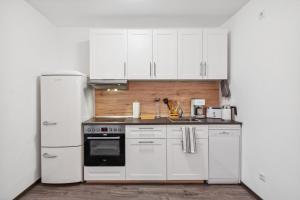 a kitchen with white cabinets and a refrigerator at Altstadt Traum für 4 in Delitzsch, Parkplatz, Wifi in Delitzsch