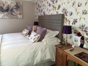 a bedroom with a bed with a teddy bear on it at Montfort Cottage Guest House in Windermere