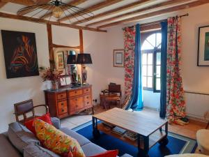 ein Wohnzimmer mit einem Sofa und einem Tisch in der Unterkunft La Ferme Neuve in Fillé