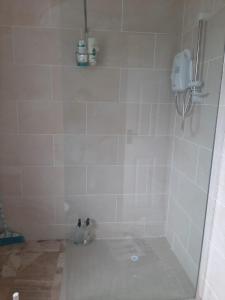 a bathroom with a shower with white tiles at Radharc an tSléibhe - Mountain View - Eircode F92R2R8 in Letterkenny