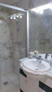 uma casa de banho branca com um lavatório e um chuveiro em Apartamento playa Cambrils Torresol 2 em Cambrils