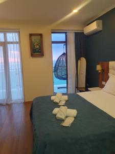 1 dormitorio con 1 cama con 2 toallas en The Fresh Wave hotel en Batumi