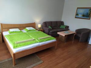 ein Schlafzimmer mit einem Bett und einem Sofa in der Unterkunft Szilvia Panzió Gyomaendrőd in Gyomaendrőd