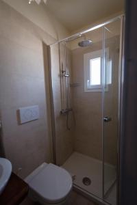 y baño con ducha, aseo y lavamanos. en Masseria Donna Palma b&b, en Pezze di Greco