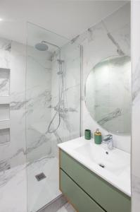 uma casa de banho branca com um lavatório e um chuveiro em Appartement T2 les pieds dans l'eau à Argeles-Sur-Mer em Argelès-sur-Mer