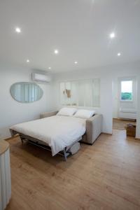een witte slaapkamer met een bed en een bank bij Appartement T2 les pieds dans l'eau à Argeles-Sur-Mer in Argelès-sur-Mer