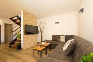 uma sala de estar com um sofá e uma televisão em Kuća za odmor Gino em Šajini