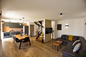 uma sala de estar e cozinha com um sofá e uma mesa em Kuća za odmor Gino em Šajini