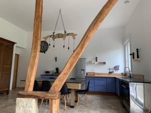 kuchnia z niebieskimi szafkami i stołem z krzesłami w obiekcie Gîte, Maison entière avec billard et bel espace de vie La Grange w mieście Blicourt