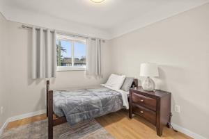 een slaapkamer met een bed, een nachtkastje en een raam bij Peaceful Escape in Victoria