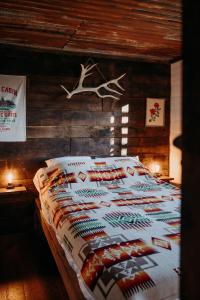 ein Schlafzimmer mit einem Bett mit einem Hirschkopf an der Wand in der Unterkunft La ferme du pont de Maumy, cabane au bord de l'étang et bain nordique in Busserolles