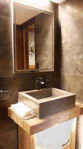 y baño con lavabo y espejo. en Casa Matilda - Apartamento con chimenea, vistas, rustico-elegante en el centro, en Sant Joan de les Abadesses