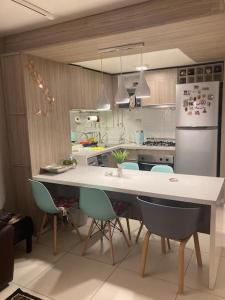 a kitchen with a table and chairs and a refrigerator at Hermosa Casa Reñaca con Vista al Mar in Viña del Mar