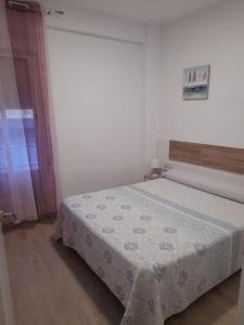 una camera da letto con un letto coperto di Apartamentos playa de bellreguard,gandia,oliva,denia,benidorm a Bellreguart