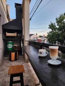 two coffee cups sitting on a table on a balcony at At Home CdelU in Concepción del Uruguay