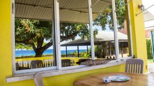 una mesa y sillas en un restaurante con vistas al océano en House of Erabo, en Runaway Bay