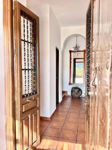 a hallway with an open door with a chair in a room at Casa Rural Sabika in Alhama de Granada