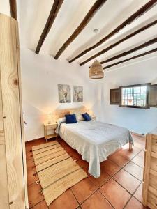 a bedroom with a bed with blue pillows on it at Casa Rural Sabika in Alhama de Granada