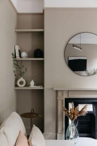 een woonkamer met een open haard en een spiegel bij The Curator's Apartment - 2 Bedrooms with parking in Bath