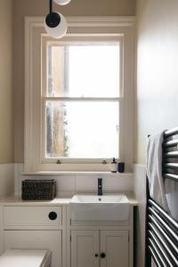 een badkamer met een wastafel en een raam bij The Curator's Apartment - 2 Bedrooms with parking in Bath