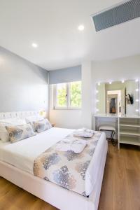 a white bedroom with a large bed and a desk at Gk Halepa Luxury apartment in Chania Town