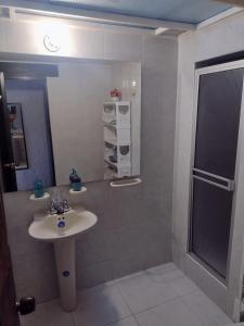 y baño con lavabo y espejo. en Casa Turística Camitas Inn, en Bogotá