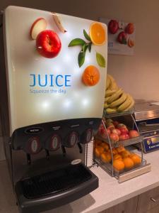 a juicer sitting on a counter with fruits and vegetables at Days Inn by Wyndham Yosemite Area in Fresno