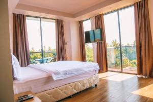 a bedroom with a bed and a large window at Ari Grand Hotel & Spa in Dhangethi