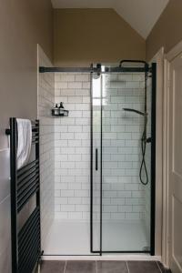 a shower with a glass door in a bathroom at The Curator's Apartment - 2 Bedrooms with parking in Bath