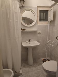 een badkamer met een wastafel en een spiegel en een toilet bij B&B Aquila in Alberobello