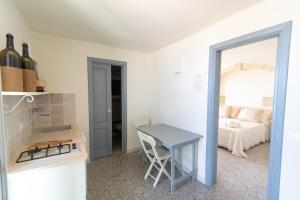 cocina pequeña con mesa y cama en Masseria Donna Palma b&b, en Pezze di Greco