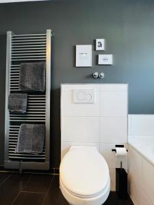 uma casa de banho com um WC branco num quarto em pottapartments - balkon - küche - wifi - nespresso em Herne