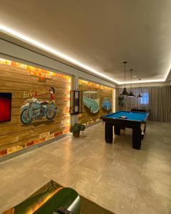 uma sala de estar com uma mesa de bilhar e um mural em Hotel Imperatriz Premium em Telêmaco Borba